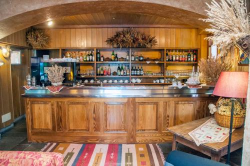 un bar con armadi in legno, tavolo e lampada di Hotel Vallée De Cogne a Cogne