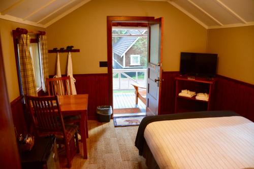 a bedroom with a bed and a door to a patio at Johnston Canyon Lodge & Bungalows in Castle Junction
