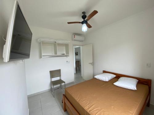 Schlafzimmer mit einem Bett und einem Deckenventilator in der Unterkunft Apartamento com excelente localização e conforto! in Ubatuba