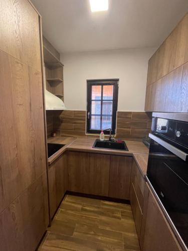 a kitchen with wooden cabinets and a sink at Mountain Villa Zlatibor in Zlatibor