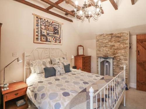 een slaapkamer met een groot bed en een open haard bij Hawthorn Cottage in Eyam