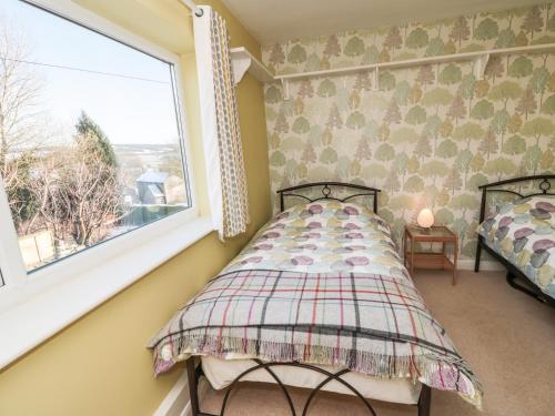 a bedroom with a bed and a window at Jasmine Cottage in Bakewell