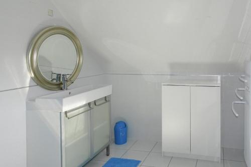 une salle de bain blanche avec un lavabo et un miroir dans l'établissement Holiday Home in Bénodet near Sandy Beach, à Bénodet