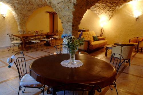 Cette chambre dispose d'une table avec un vase de fleurs. dans l'établissement Le Clos de Lumière, à La Roche-des-Arnauds