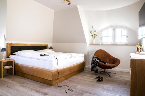 a bedroom with a bed and a chair at Ferienhaus Seeadler 65 in Fuhlendorf