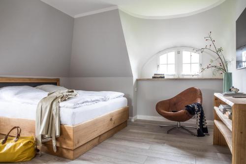 ein Schlafzimmer mit einem Bett und einem Stuhl in der Unterkunft Ferienhaus Seeadler 7 in Fuhlendorf