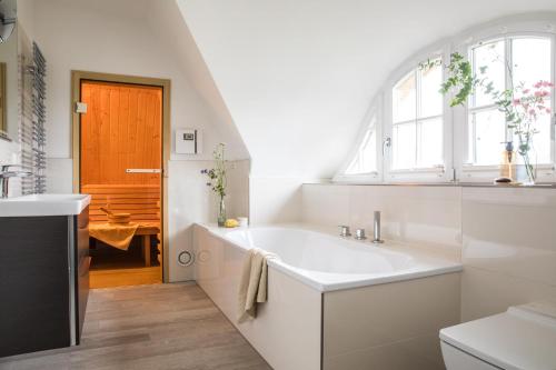 łazienka z dużą białą umywalką i oknem w obiekcie Ferienhaus Seeadler 7 w mieście Fuhlendorf