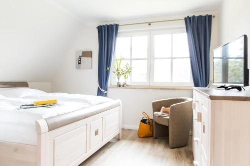 a bedroom with a large white bed and a window at Ferienhaus Seeschwalbe 10 in Fuhlendorf