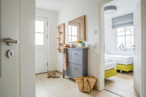 a bathroom with a mirror and a dresser in a room at Ferienwohnung Duene 2_2 in Groß Kirr