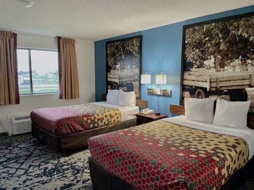 a hotel room with two beds and a window at Lamoni Inn & Suites in Lamoni