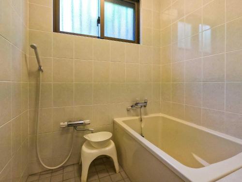 a bathroom with a tub and a toilet and a sink at Kachibai in Ishigaki Island