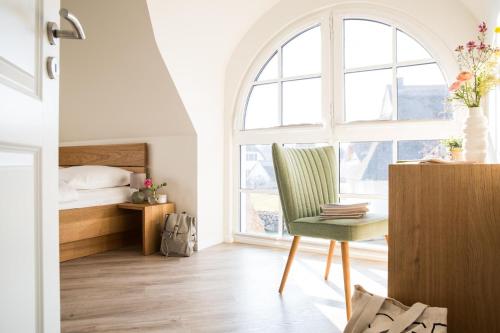 a bedroom with a bed and a desk and a chair at Ferienhaus Schilfrohrsaenger 6 in Fuhlendorf