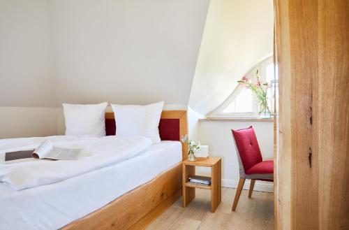 ein Schlafzimmer mit einem Bett und einem roten Stuhl in der Unterkunft Ferienhaus Seeadler 34 in Fuhlendorf