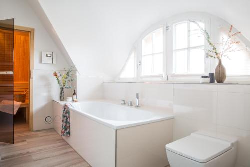 a white bathroom with a sink and a toilet at Ferienhaus Seeadler 9 in Fuhlendorf