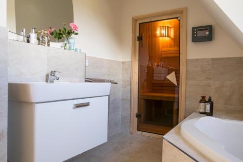 a bathroom with a sink and a tub and a shower at Ferienhaus Seeschwalbe 55 in Fuhlendorf