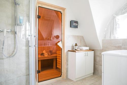 a bathroom with a shower with a glass door at Ferienhaus Haubenlerche 16 in Fuhlendorf
