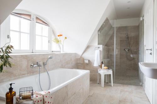 a bathroom with a tub and a shower and a sink at Ferienhaus Seeadler 24 in Fuhlendorf