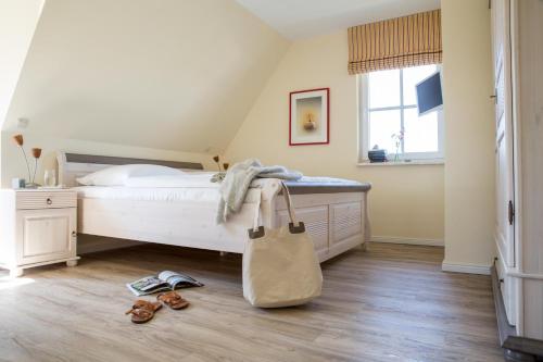 a bedroom with a bed with a white bedvisor at Ferienhaus Schilfrohrsaenger 48 in Fuhlendorf