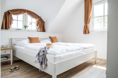 um quarto com uma cama branca e um espelho em Ferienwohnung Buhnen 2_4 em Groß Kirr