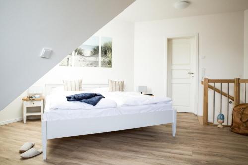 Groß KirrにあるFerienwohnung Diek 1_5の白いベッドルーム(白いベッド1台、階段付)