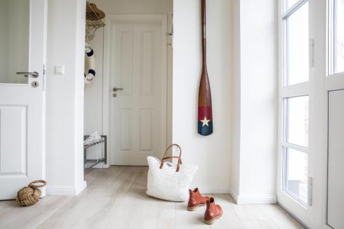 a hallway with red shoes and a white door at Ferienhaus Seeschwalbe 44 in Fuhlendorf