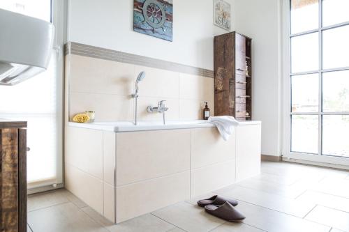 a white bathroom with a sink and a mirror at Ferienhaus Haubenlerche 32 in Fuhlendorf