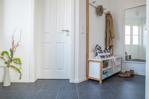 a hallway with a white door and a mirror at Ferienhaus Schilfrohrsaenger 45 in Fuhlendorf