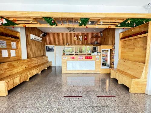 a restaurant with wooden benches and a kitchen at Lee Place Phatthanakan Condo in Bangkok