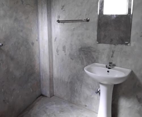 a bathroom with a white sink and a mirror at The Esence of Sri Lanka in Ahungalla