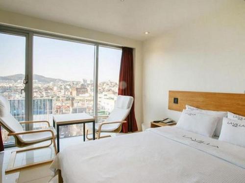 a hotel room with a bed and a table and chairs at La Villa Hotel in Seoul