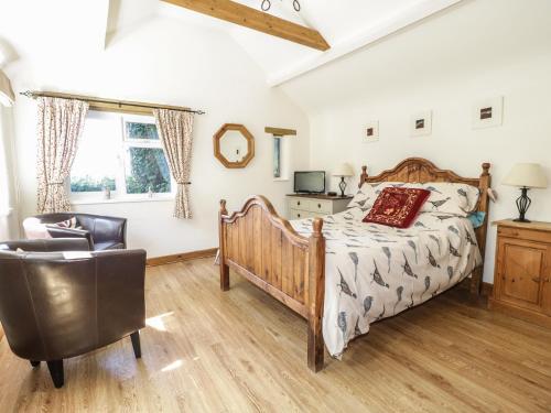a bedroom with a bed and a chair at The Mouse House in Blandford Forum