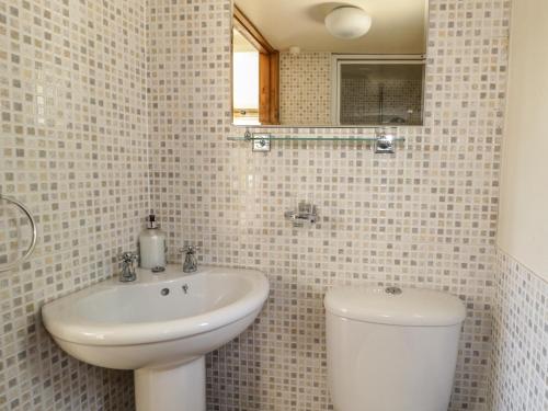 a white bathroom with a sink and a toilet at The Mouse House in Blandford Forum