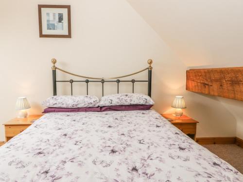 a bedroom with a large bed with two lamps at Foxhunter Cottage in Whitby