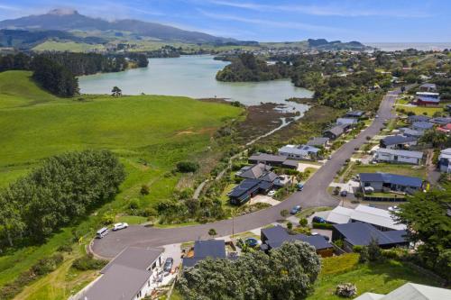 an aerial view of a village next to a river at R and R at Robertson - Raglan Holiday Home in Raglan
