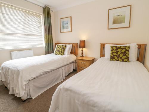 a bedroom with two beds and a window at Ladybird in Bridgwater