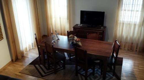 a dining room with a table and a television at Cantinho da Estrela in Seia