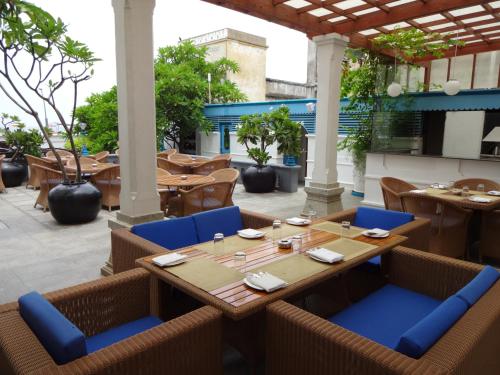 a restaurant with blue chairs and tables on a patio at The Promenade in Puducherry