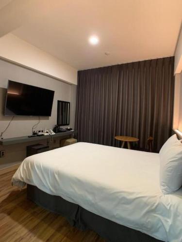 a hotel room with a large bed and a flat screen tv at Jeju Renaissance Hotel in Jeju