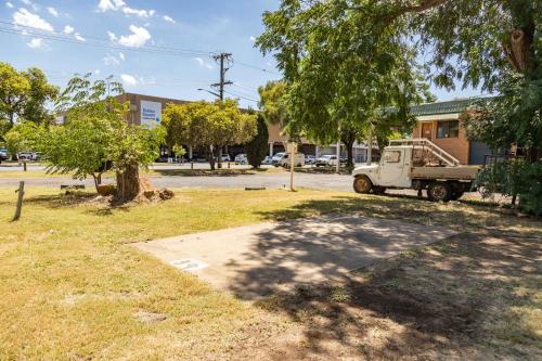 a truck parked in a yard with a tree at Western Plains Tourist Park - Dubbo in Dubbo