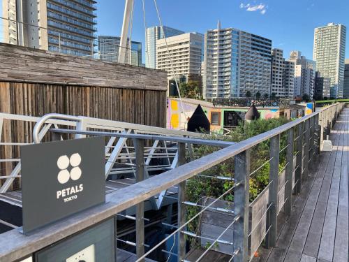 a sign on a bridge with a city in the background at PETALS TOKYO - Floating Hotel in Tokyo