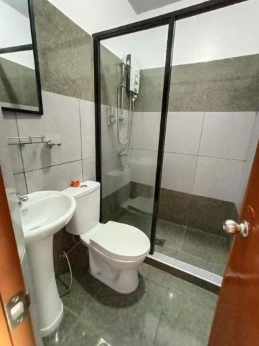 a bathroom with a toilet and a shower and a sink at Garden Village Resort in Moalboal