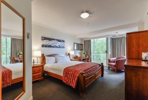 um quarto de hotel com uma cama e uma cadeira em Burnett Riverside Hotel em Bundaberg