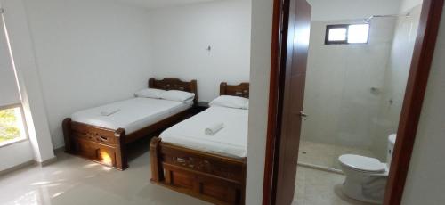 a bathroom with two beds and a toilet and a shower at Hotel Perla Real in Santa Marta