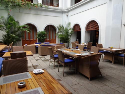 un restaurante con mesas y sillas en un edificio en Le Dupleix en Pondicherry