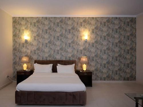 ein Schlafzimmer mit einem großen Bett mit zwei Leuchten an der Wand in der Unterkunft Gulshan Family Couple Guest House Couple Hotel Gulshan-e-iqbal in Karatschi