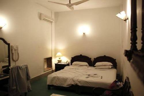 Schlafzimmer mit einem Bett und einem Spiegel in der Unterkunft Gulshan Family Couple Guest House Couple Hotel Gulshan-e-iqbal in Karatschi