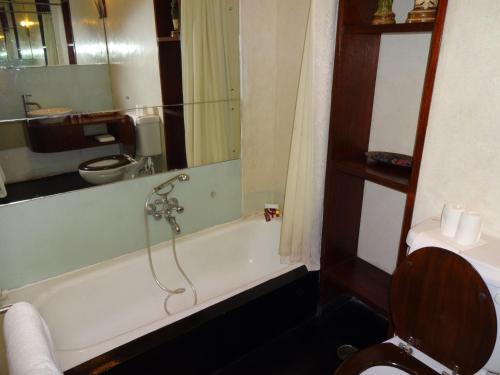 a bathroom with a bath tub and a toilet at Le Dupleix in Pondicherry