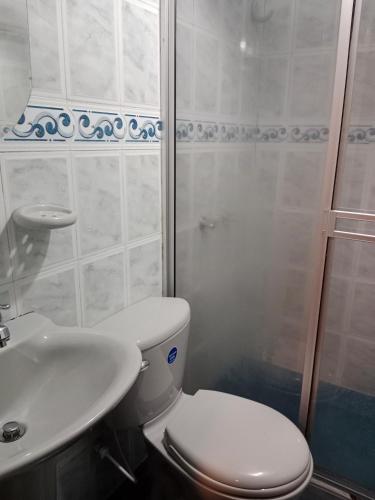 a bathroom with a toilet and a sink and a shower at HOTEL GALERAS in Pasto