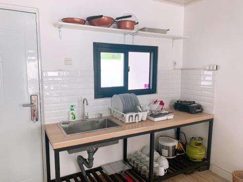 eine Küchentheke mit Spüle und Fenster in der Unterkunft Casa de Gaudi Lembang in Lembang