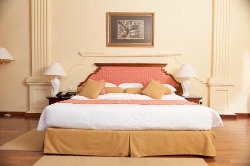 a bedroom with a large bed with a red headboard at Mahaweli Reach Hotel in Kandy